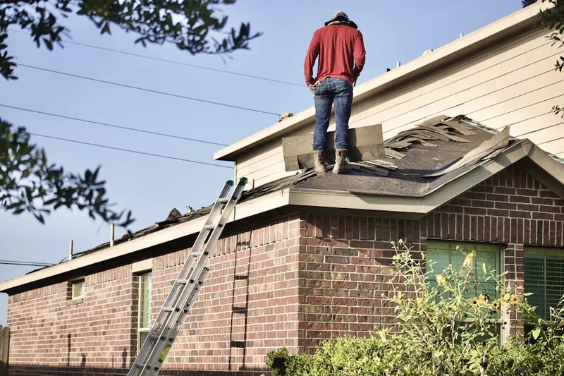 Professional roofer working on a residential roof in Sunset Park